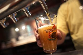 The bartender poured a beer into a glass